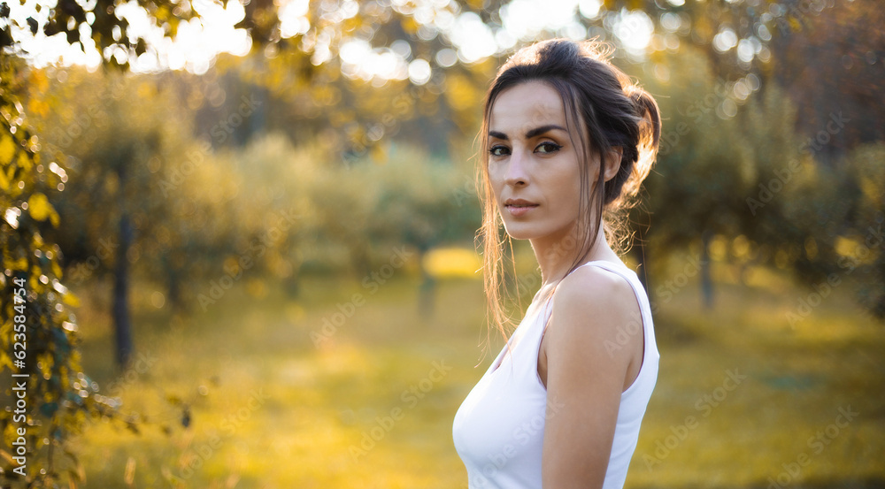 Close up portrait of an adorable and gorgeous brunette woman with profashion make up and hairstyle posing outdoors in sunset with rays of sun. Fashion, style, trendy, model Close up portrait of an adorable and gorgeous brunette woman with profashion make up and hairstyle posing outdoors in sunset with rays of sun. Fashion, style, trendy, model