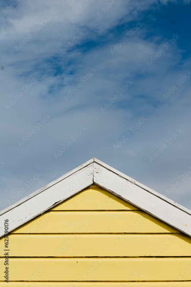 Portrait image of old English beach hut in blue and white with copy space