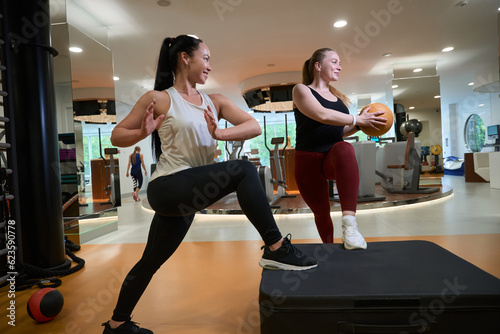 Fitness trainer works with a client in fitness clinic gym
