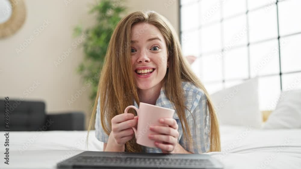 Young blonde woman doing video call with laptop drinking coffee at bedroom Young blonde woman doing video call with laptop drinking coffee at bedroom