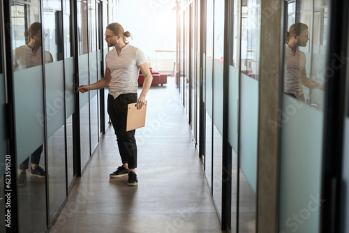 Bearded employee in glasses opens the door