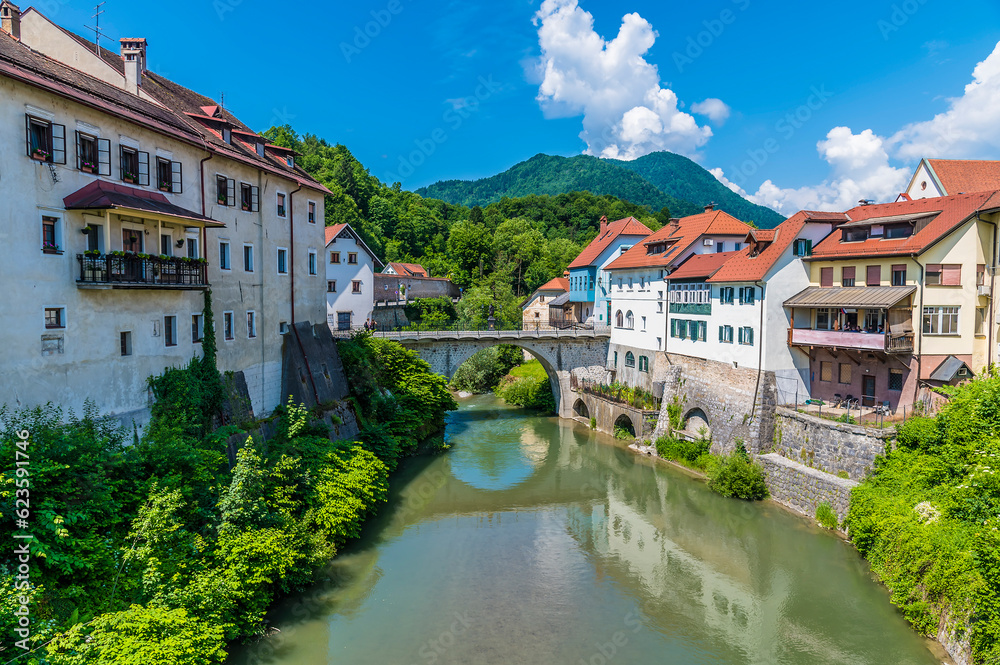 A view up the Selca Sora River towards the fourteenth century Capuchin Bridge in the town of Skofja Loka, Slovenia in summertime