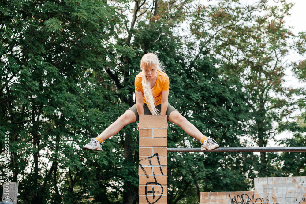 Naklejka premium Adventurous girl balances atop a playground structure, showcasing bold childhood spirit.