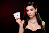 Stunning female dealer hold poker game two ace cards betting gambling poker club poker night lighted by neon filters