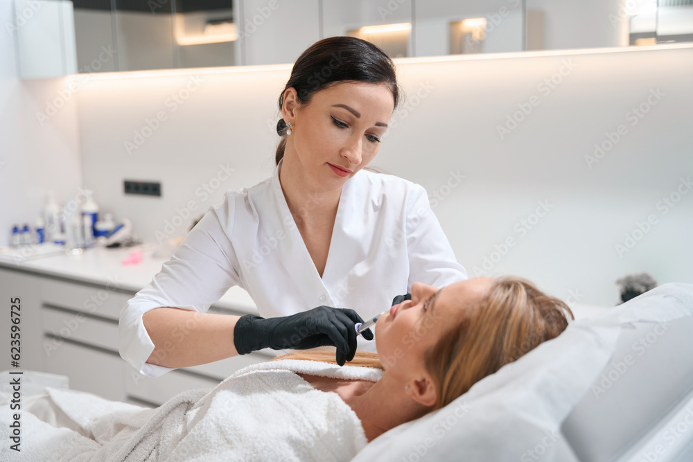 Specialist in a cosmetology clinic makes a beauty injection Specialist in a cosmetology clinic makes a beauty injection