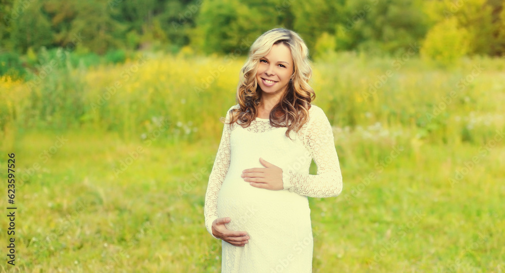 Portrait of happy young pregnant woman walking in summer park Portrait of happy young pregnant woman walking in summer park