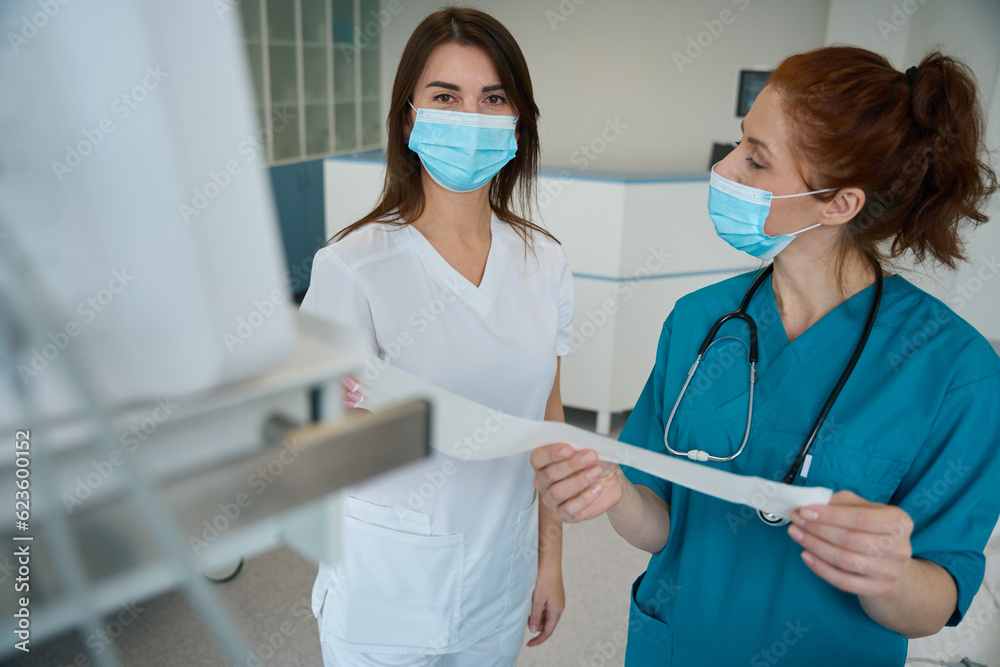 Nurse and doctor discussing analysis in ward