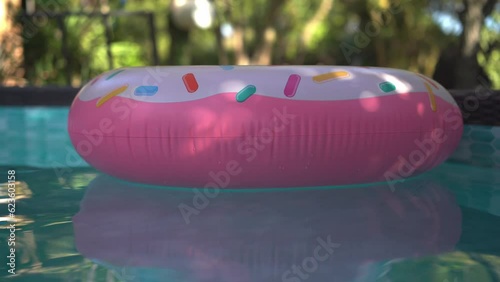 Inflable donut pool float circling in a private pool photo