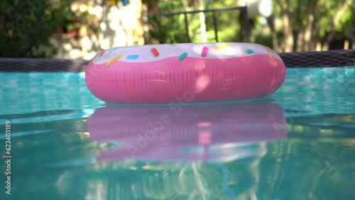 Inflable donut pool float circling in a private pool photo