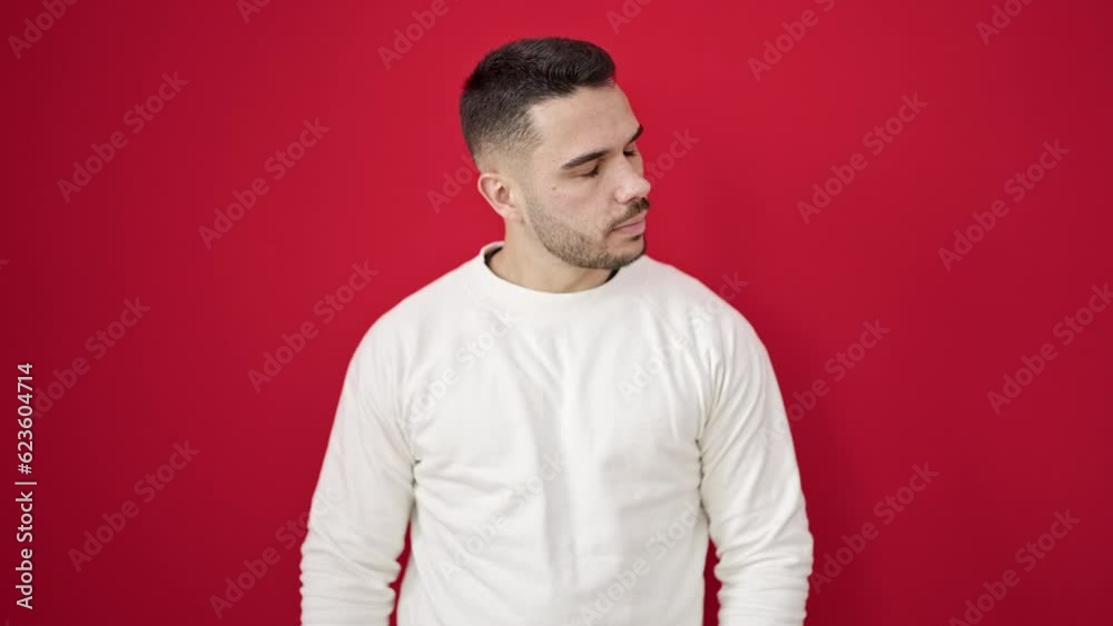 Young hispanic man saying no with finger over isolated red background Young hispanic man saying no with finger over isolated red background