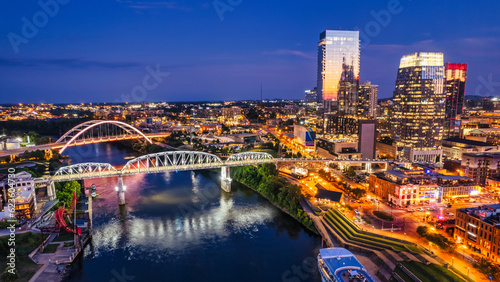 Aerial view of the Korean Veteran War Memorial Bridge and the John Seigenthaler Pedestrian Bridge crossing the Cumberland River in Nashville at dusk.