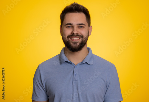 Portrait of happy calm caucasian man smiling friendly, glad expression looking away dreaming resting, relaxation feel satisfied concept good news, celebrate win. Guy on studio yellow background indoor