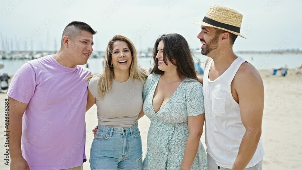 Group of people hugging each other smiling at beach Group of people hugging each other smiling at beach