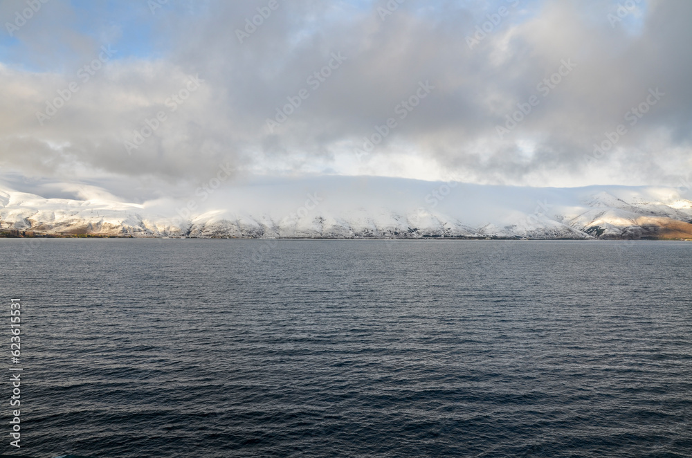 View to calm water surface of lake Sevan and snow capped mountains in distance. Picturesque landmark of Armenia View to calm water surface of lake Sevan and snow capped mountains in distance. Picturesque landmark of Armenia