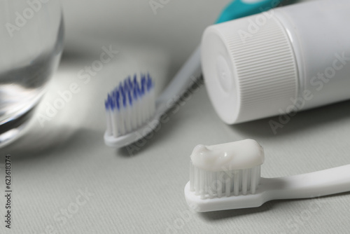 Plastic toothbrush with paste on grey background  closeup
