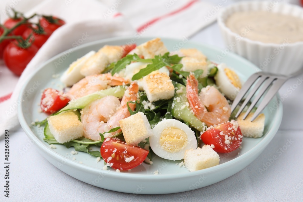 Delicious Caesar salad with shrimps on white table, closeup Delicious Caesar salad with shrimps on white table, closeup
