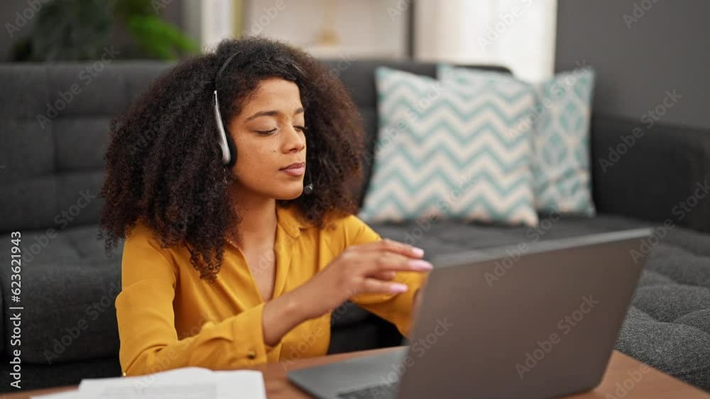 African american woman call center agent smiling working taking out headphones relaxing at home African american woman call center agent smiling working taking out headphones relaxing at home