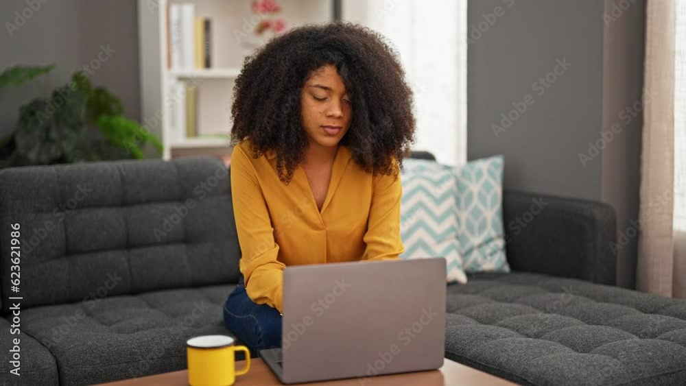 African american woman using laptop stressed at home