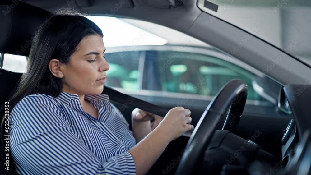 Young beautiful hispanic woman wearing car belt at parking lot Young beautiful hispanic woman wearing car belt at parking lot