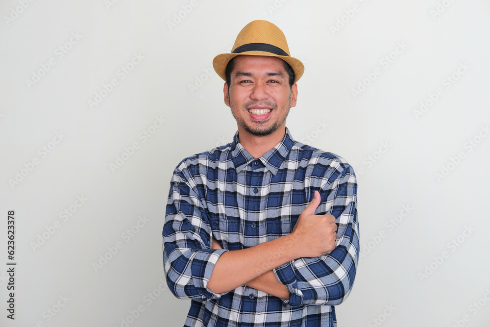 Adult Asian man smiling with cross arms give thumb up Adult Asian man smiling with cross arms give thumb up