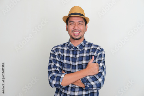 Adult Asian man smiling with cross arms give thumb up