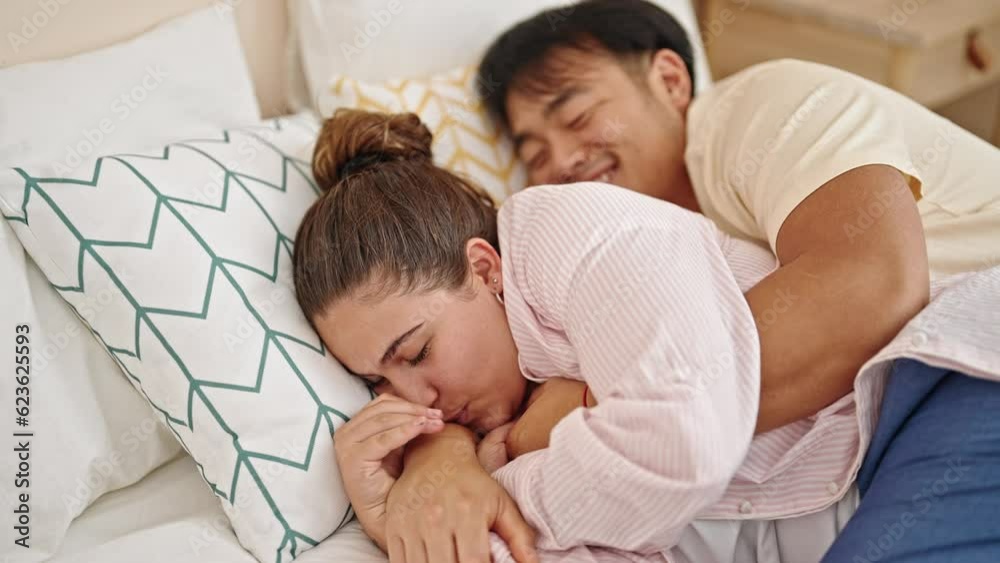Man and woman couple lying on bed hugging each other at bedroom Man and woman couple lying on bed hugging each other at bedroom