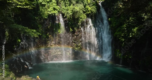 Waterfall and rainbow in the tropical mountain jungle. Tinago Falls. Mindanao, Philippines. Travel concept. photo