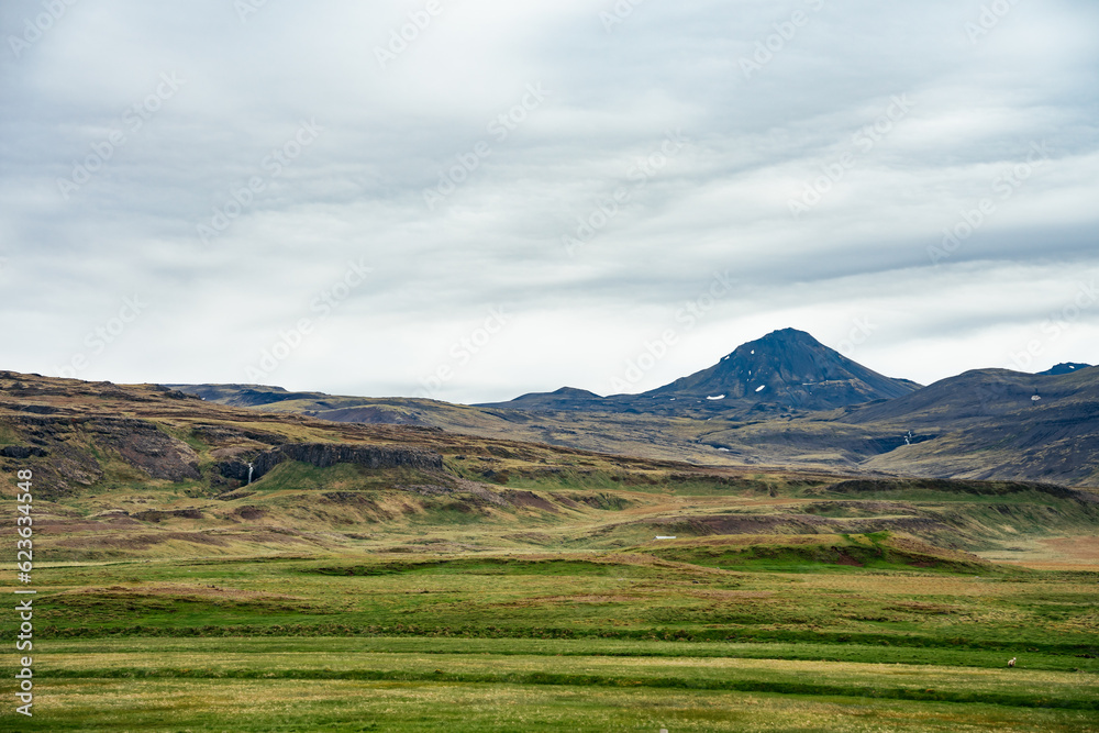 View across the grassy plains with a volcanic crater in the Snæfellsnes peninsular in west Iceland