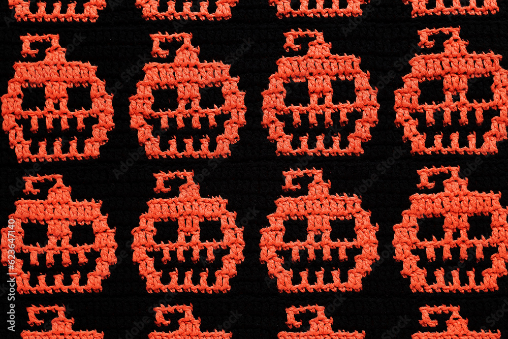 Festive Halloween seamless crochet fabric. Mosaic crochet orange black pumpkins pattern. Festive Halloween seamless crochet fabric. Mosaic crochet orange black pumpkins pattern.