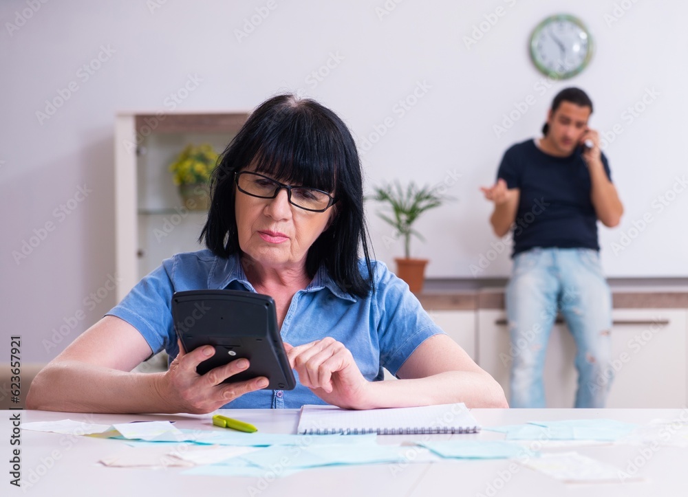 Female pensioner and her young son in budget planning concept Female pensioner and her young son in budget planning concept