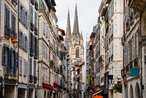 Alley with old buildings and cathedral towers in the background in the city of Bayonne in the south of France. photo