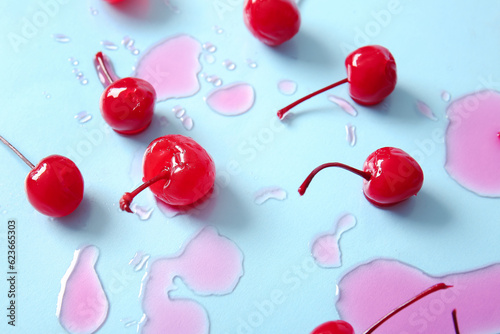 Tasty maraschino cherries on blue background photo