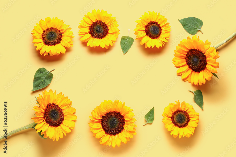 Frame made of beautiful sunflowers and leaves on yellow background Frame made of beautiful sunflowers and leaves on yellow background