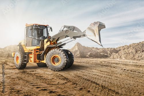 Wheel front loader or bulldozer at a construction site in a quarry. Powerful modern equipment for earthworks. Construction site. Rental of construction equipment.