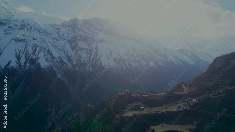 Aerial high top down view abandoned village buildings with snowy peaks background. Annapurna circuit trek. Manang district in Nepal. Himalayas trekking and sightseeing. Aerial high top down view abandoned village buildings with snowy peaks background. Annapurna circuit trek. Manang district in Nepal. Himalayas trekking and sightseeing.