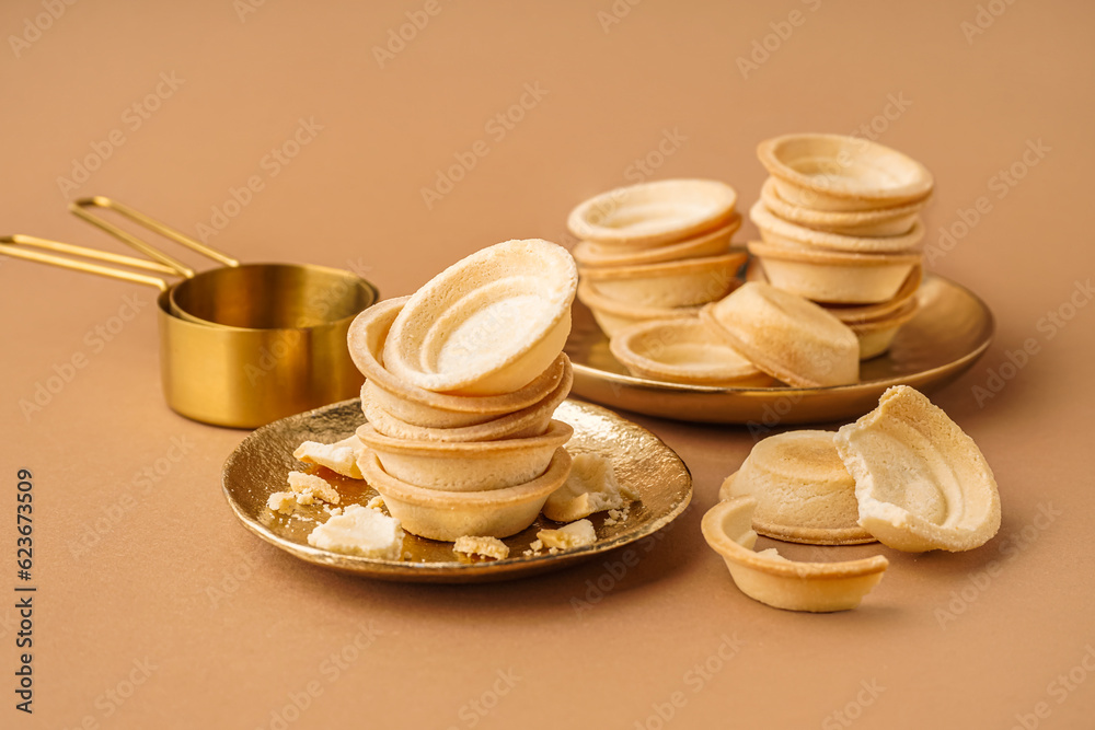 Plates with homemade tartlets on brown background