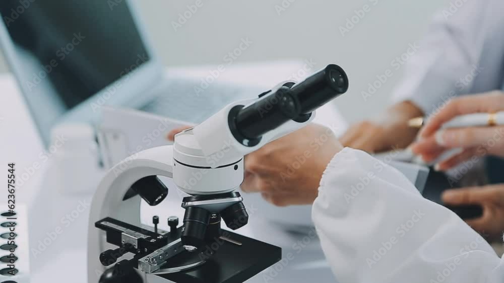 Team of Medical Research Scientists Collectively Working on a New Generation Experimental Drug Treatment. Laboratory Looks Busy, Bright and Modern. Team of Medical Research Scientists Collectively Working on a New Generation Experimental Drug Treatment. Laboratory Looks Busy, Bright and Modern.
