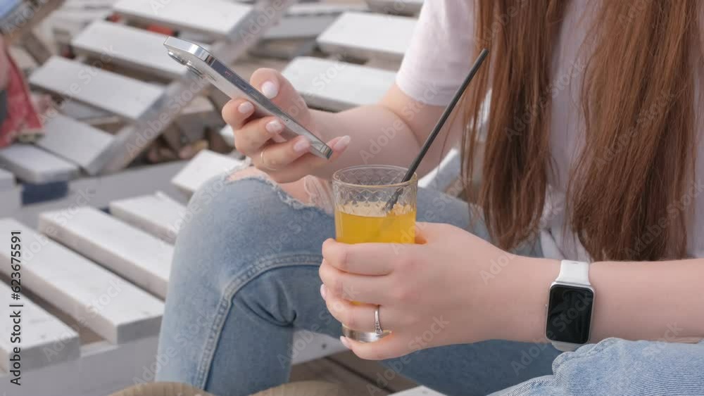 Millenial girl using smartphone on beach sea on sunset. Always connected generation communicate via internet.