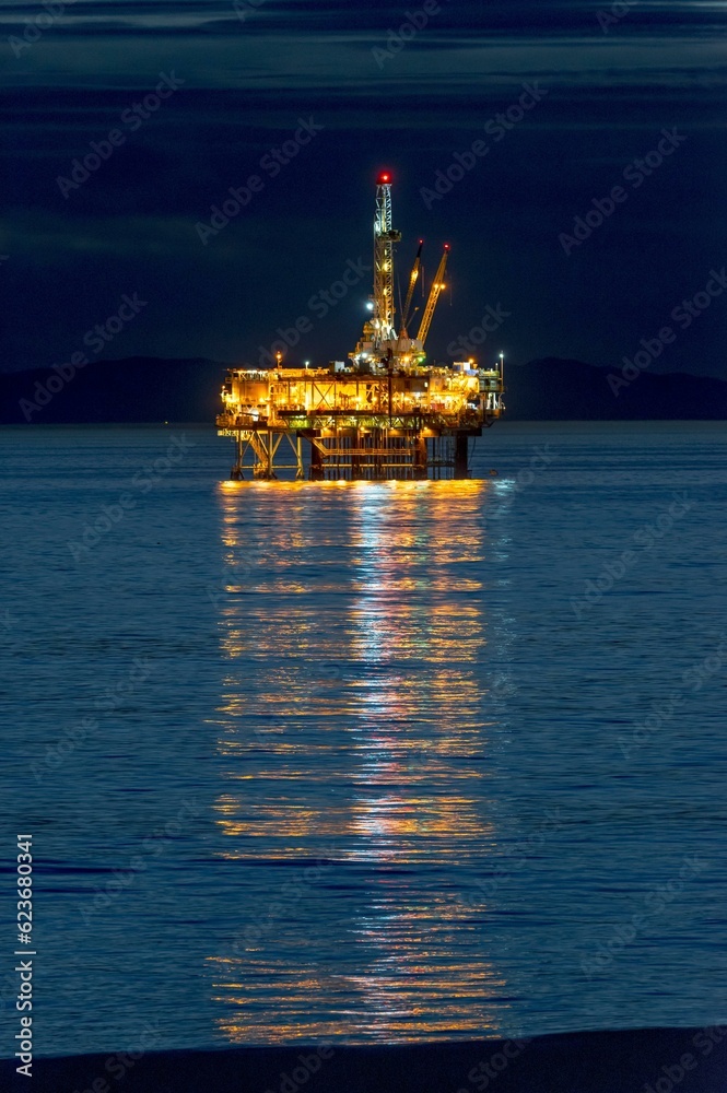 Coastal Convergence: Oil Rig and Surfer at Huntington Beach, California, Harmoniously Uniting on Film in 4K Resolution