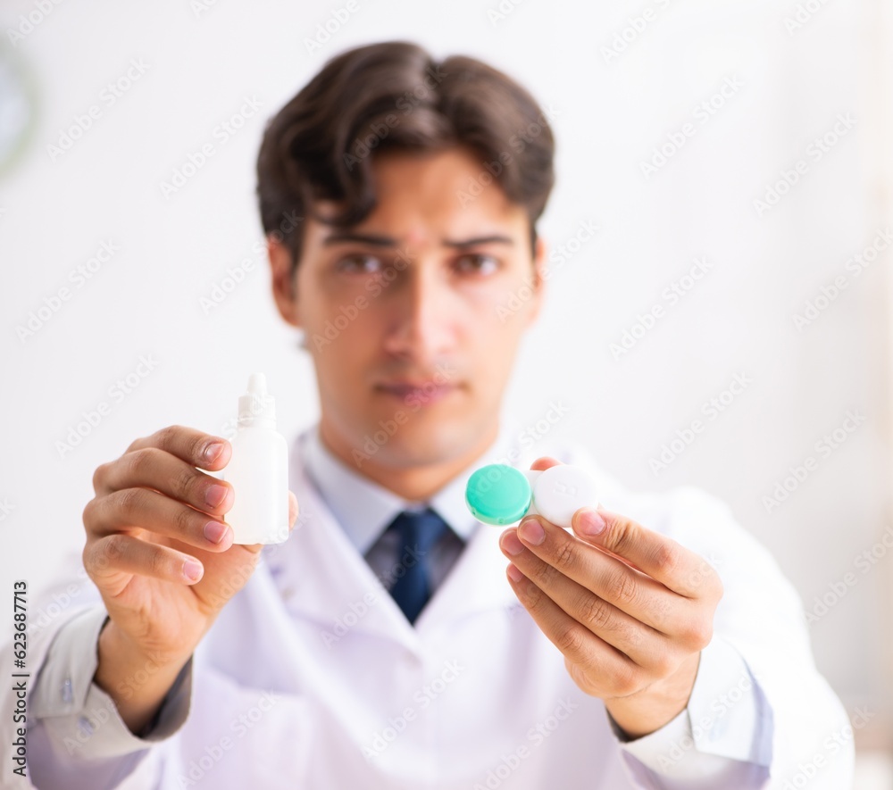 Young handsome doctor oculist working at the clinic Young handsome doctor oculist working at the clinic