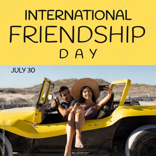 International friendship day text with happy caucasian couple taking selfie in car on beach