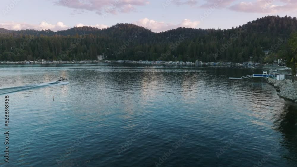 Aerial view of speedboat moving on Lake Arrowhead in the San Bernardino Mountains, Los Angeles, California, USA. Drone shot of motorboat riding along lakeside at sunset. Water activities, 4k footage Aerial view of speedboat moving on Lake Arrowhead in the San Bernardino Mountains, Los Angeles, California, USA. Drone shot of motorboat riding along lakeside at sunset. Water activities, 4k footage