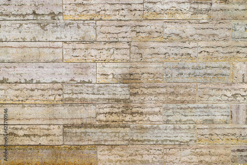 Texture of an old beige stone wall made of limestone blocks as an architectural background