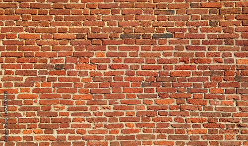 Texture of an old and damaged orange brick wall as an architectural background