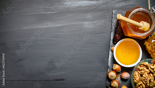 Honey background. Fresh honey in the pot with the nuts. On a black chalkboard.