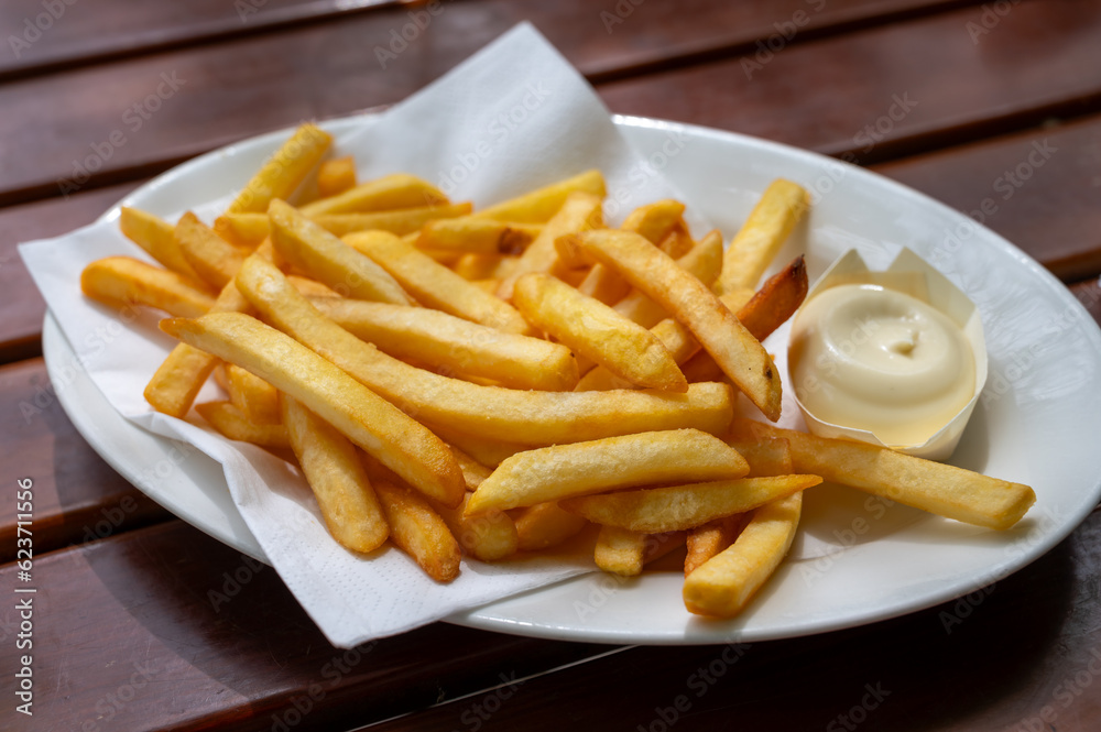 Eating of street or take away food fresh baked french fried potatoes chips with Belgian mayonnaise Eating of street or take away food fresh baked french fried potatoes chips with Belgian mayonnaise