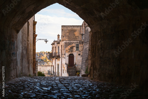 Fototapeta Naklejka Na Ścianę i Meble -  Quaint cobblestone street at sun rise, Matera, Italy