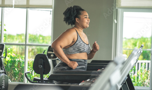 girl plus size women in sports bras walking and running on the treadmill weight loss and exercise in the gym
