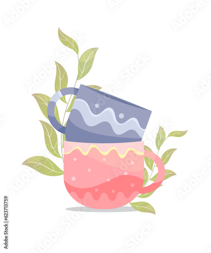 Two coffee cups one on the other cup blue and rose color with a leaves aside