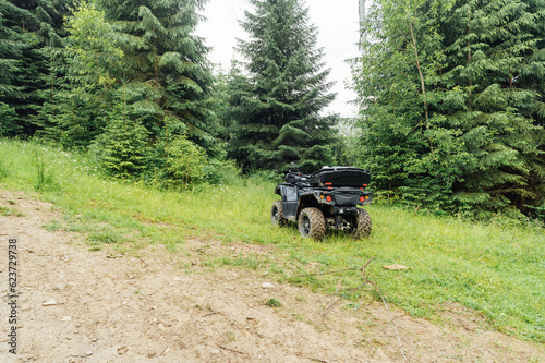 Photo of the lost ATV among the coniferous forest in the mountains